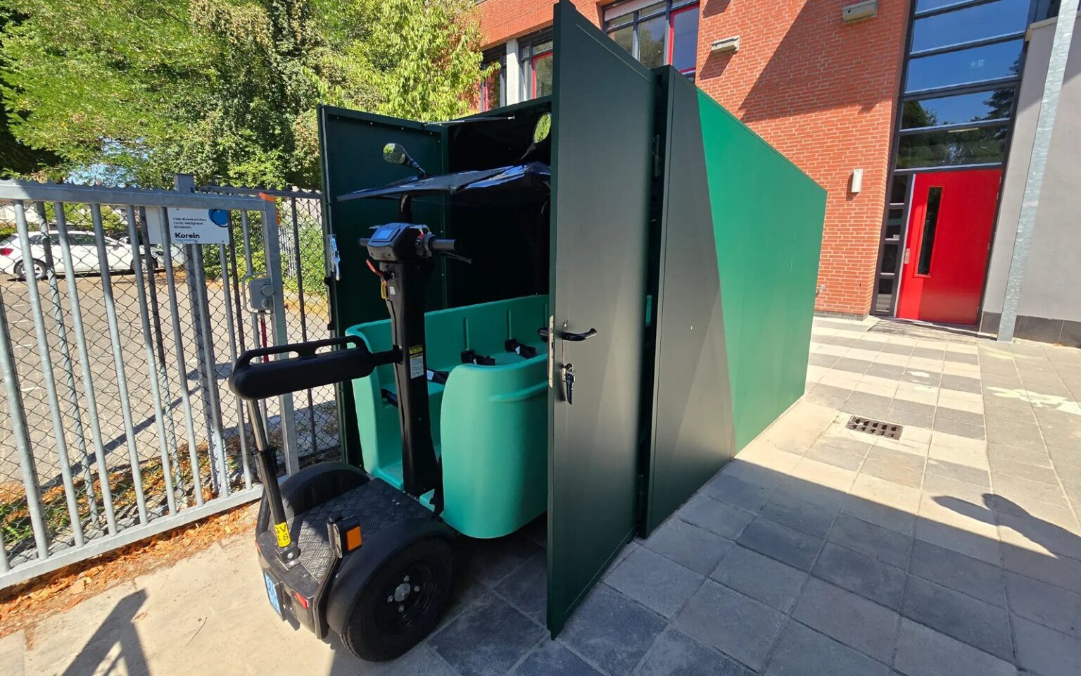 BSO bus rijdt een groene BSO-busstalling van Mobishield in bij een kinderopvanglocatie
